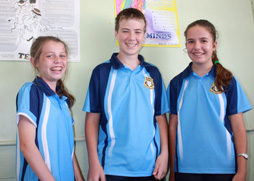 Three junior students laughing whilst posing.