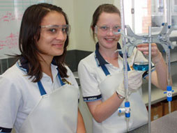 Two female students in science class doing experiment.