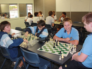 Students in class sitting at desks playing chess.